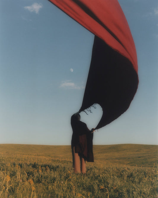 Woman holding scarf in the wind.