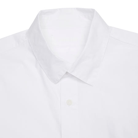 A classic white shirt with a regular cut and full-button closure. Featuring cross over detail at the collar, narrow, gathered cuffs, and a curved hem.  100% Cotton.