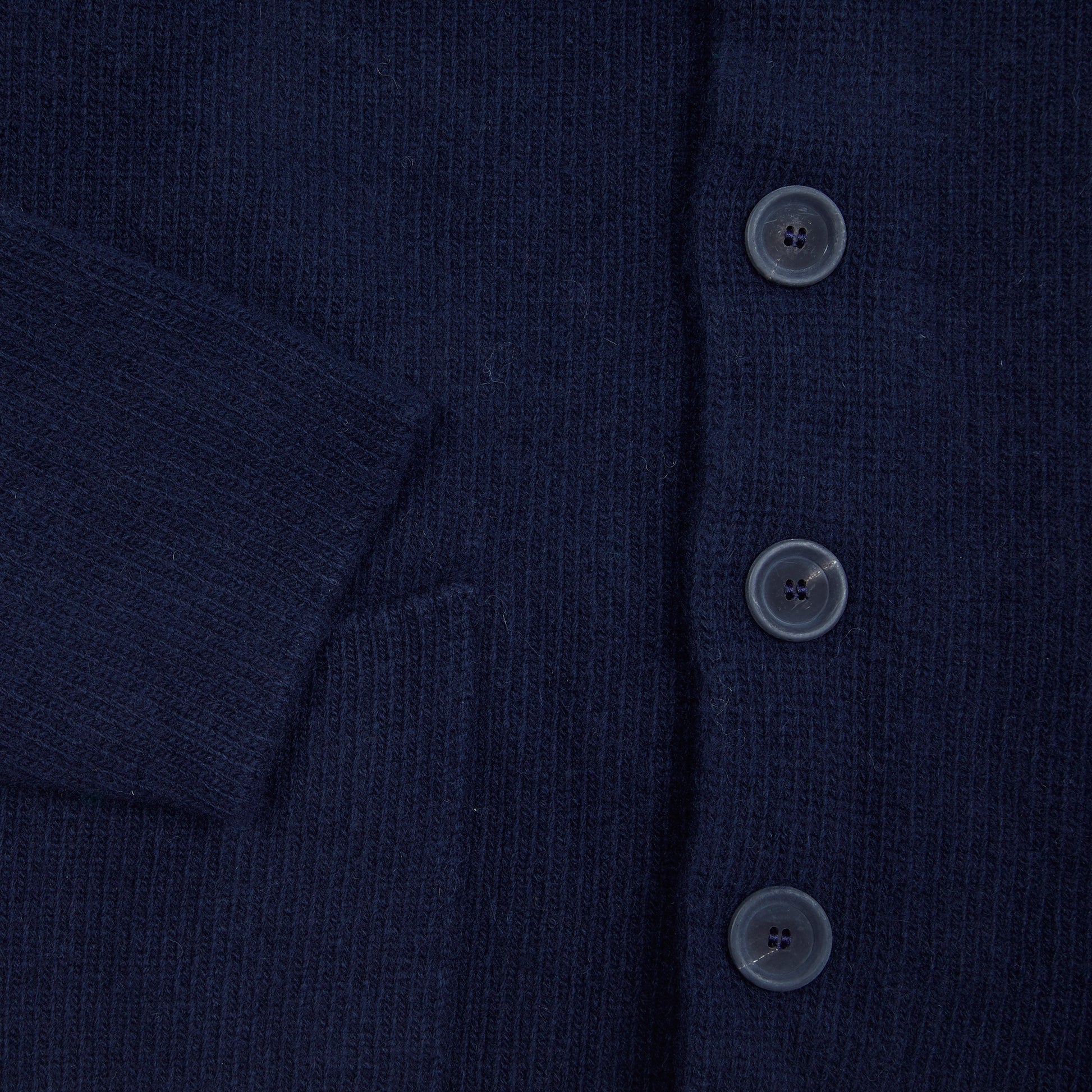 In solid navy, the Storm Jacket from Inis Meáin is inspired by island life and outdoor working in all weathers. Featuring knitted shoulder patches providing additional warmth and protection, patch pockets, a funnel collar, and finished with real horn buttons. The Storm Jacket is both functional and elegant.  70% Merino Wool, 30% Cashmere.   Made in Ireland.