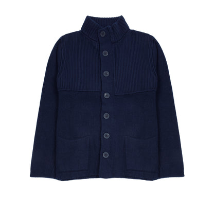 In solid navy, the Storm Jacket from Inis Meáin is inspired by island life and outdoor working in all weathers. Featuring knitted shoulder patches providing additional warmth and protection, patch pockets, a funnel collar, and finished with real horn buttons. The Storm Jacket is both functional and elegant.  70% Merino Wool, 30% Cashmere.   Made in Ireland.