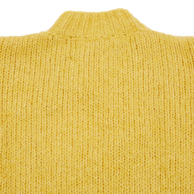 The Plasterer Jumper in Sulphur is a luxuriously soft chunky knit alpaca wool jumper with a high neck, long sleeve and oversized boxy fit. The neck and cuff both feature comfortable rib details and the sides features small side vents to sit easily at the waist.  62% Baby Alpaca, 11% Fine Merino, 27% Bio Cotton.   Made in U.K.